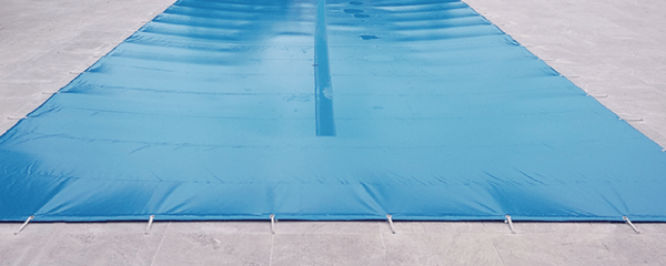 ¿Para qué sirven los agujeros o malla de drenaje en un cobertor para piscina?